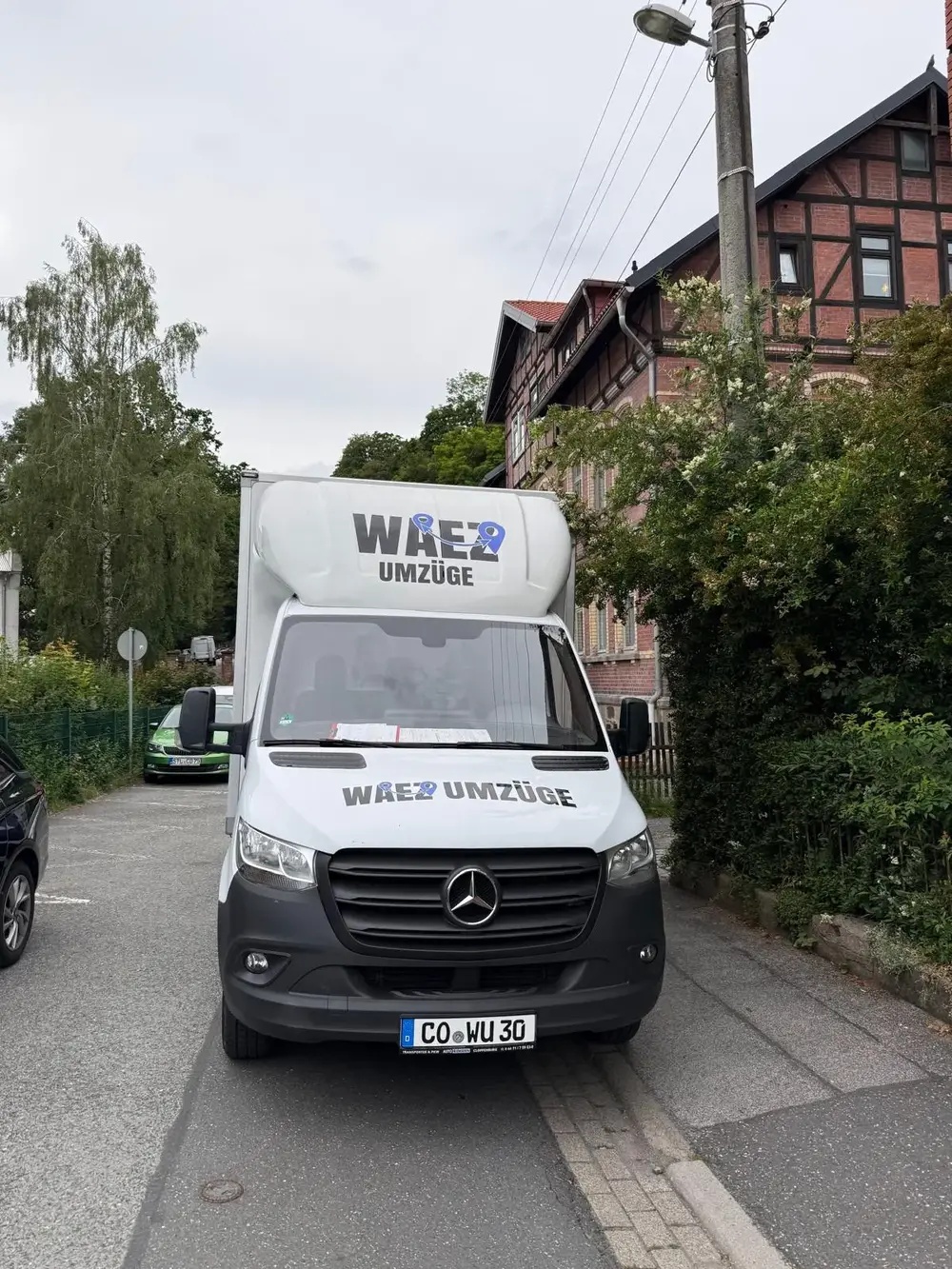 Transporter von WAEZ Umzüge in einer engen Wohnstraße beim Möbeltransport